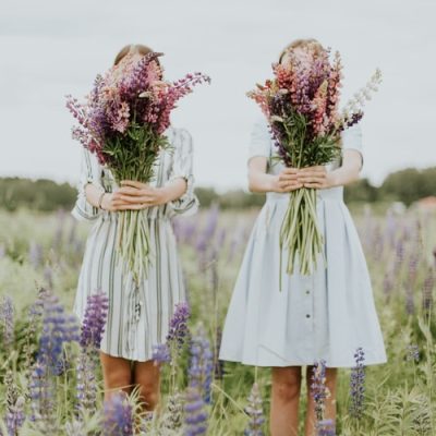 two-girls-covering-their-faces-with-flowers